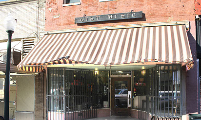 Inside the Gist Music store in Helena, Arkansas, with guitars, vinyl records, and staff at work